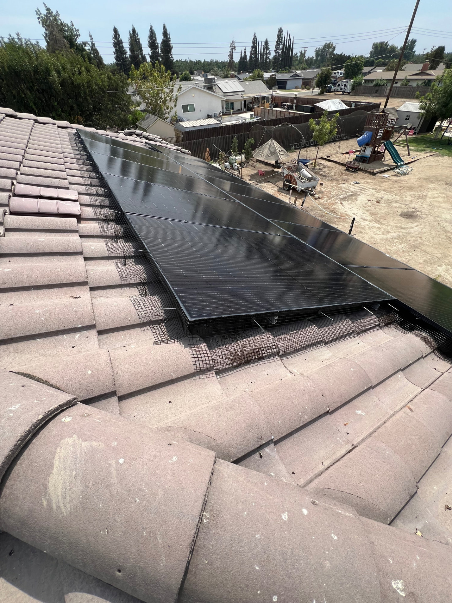 Solar array with black bird guard mesh installed around the panel perimeter